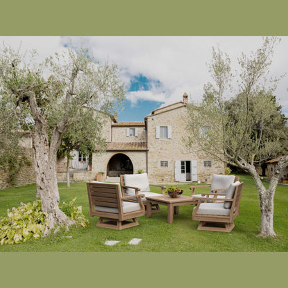 Outdoor furniture set on a grassy area with a stone building in the background