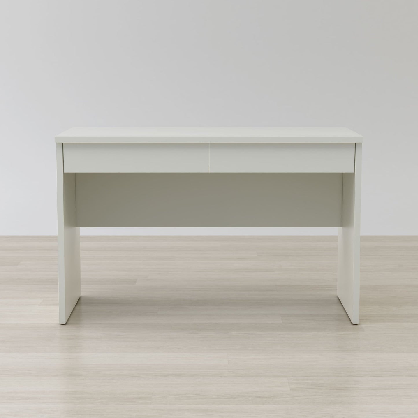 White desk with a light gray panel on a wooden floor and white wall background