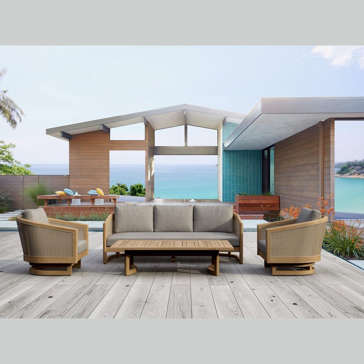 Outdoor patio set with sofa, chairs, and coffee table on a wooden deck with ocean view.