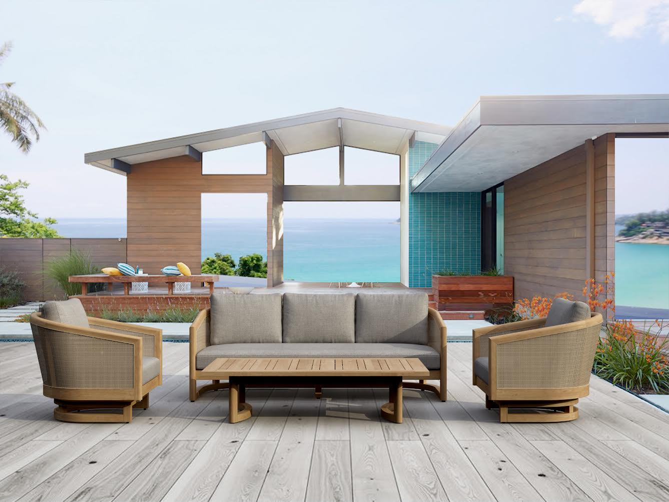 Outdoor patio set with sofa, chairs, and coffee table on a wooden deck with ocean view.