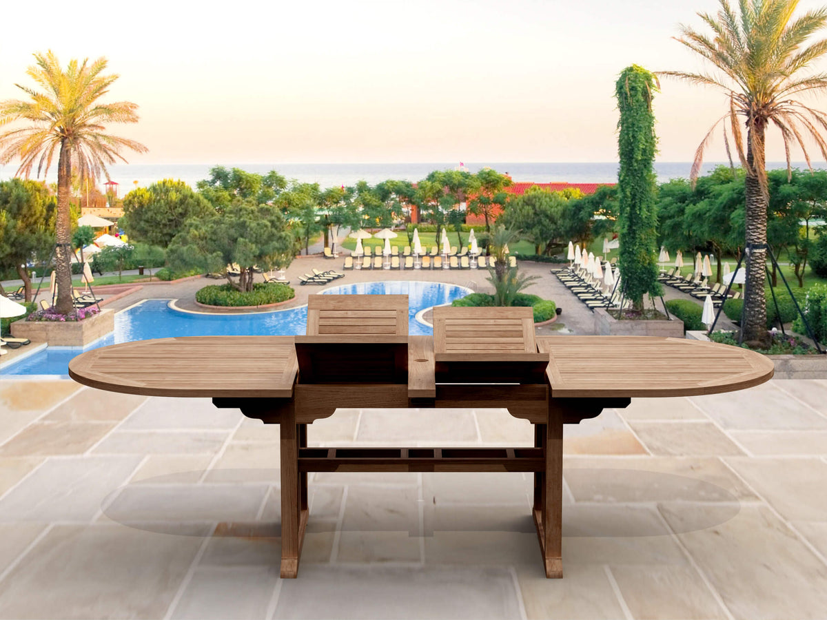 Wooden outdoor dining table with chairs in a luxurious garden setting with palm trees and a pool.