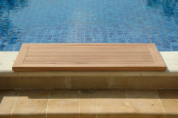Wooden deck board on a stone ledge by a pool