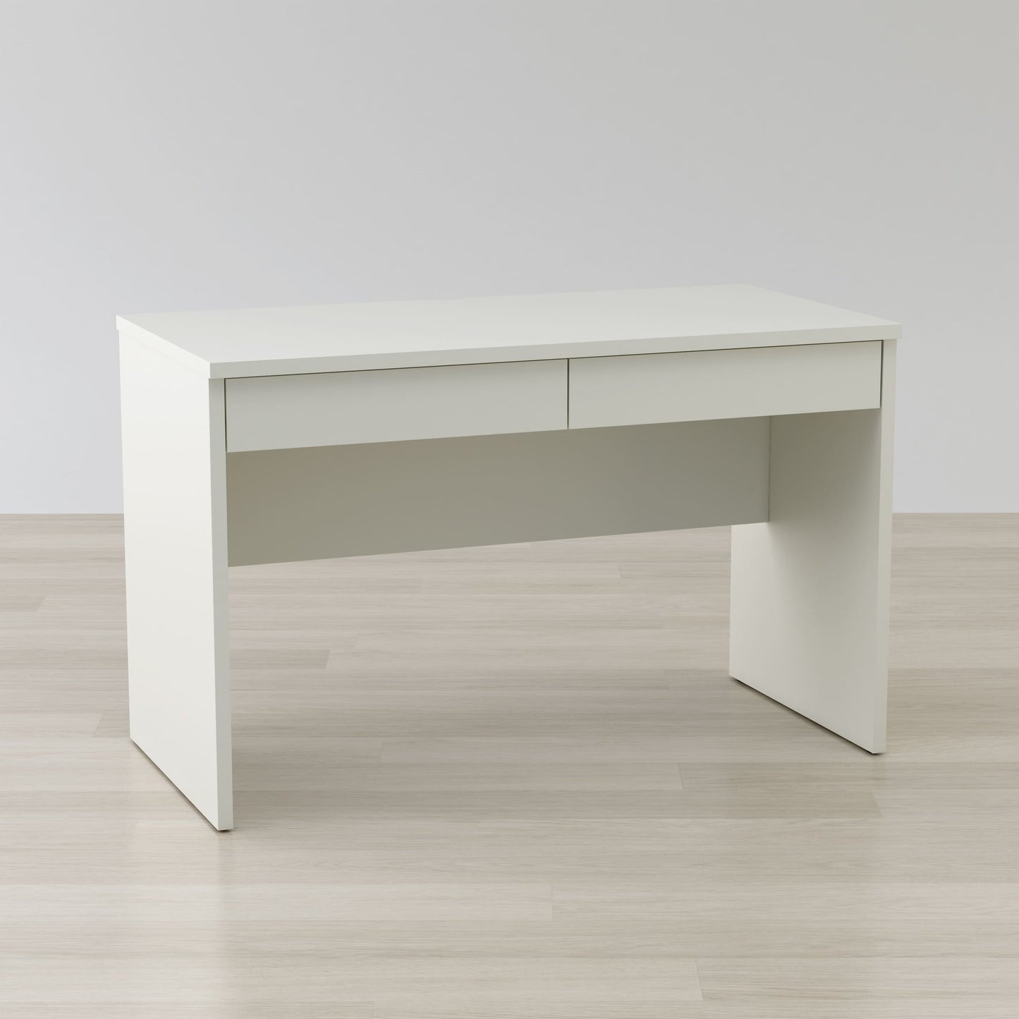 White office desk on a light wooden floor with a plain white wall background