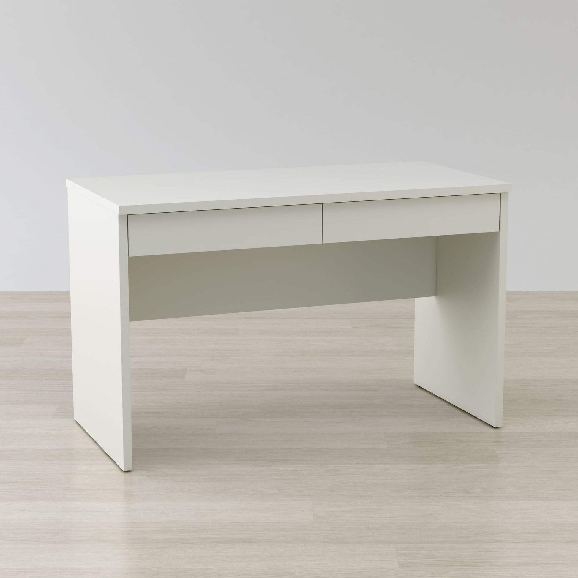 White office desk on a light wooden floor with a plain white wall background