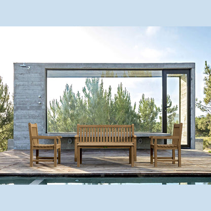 Wooden outdoor furniture set on a deck with a modern building and trees in the background