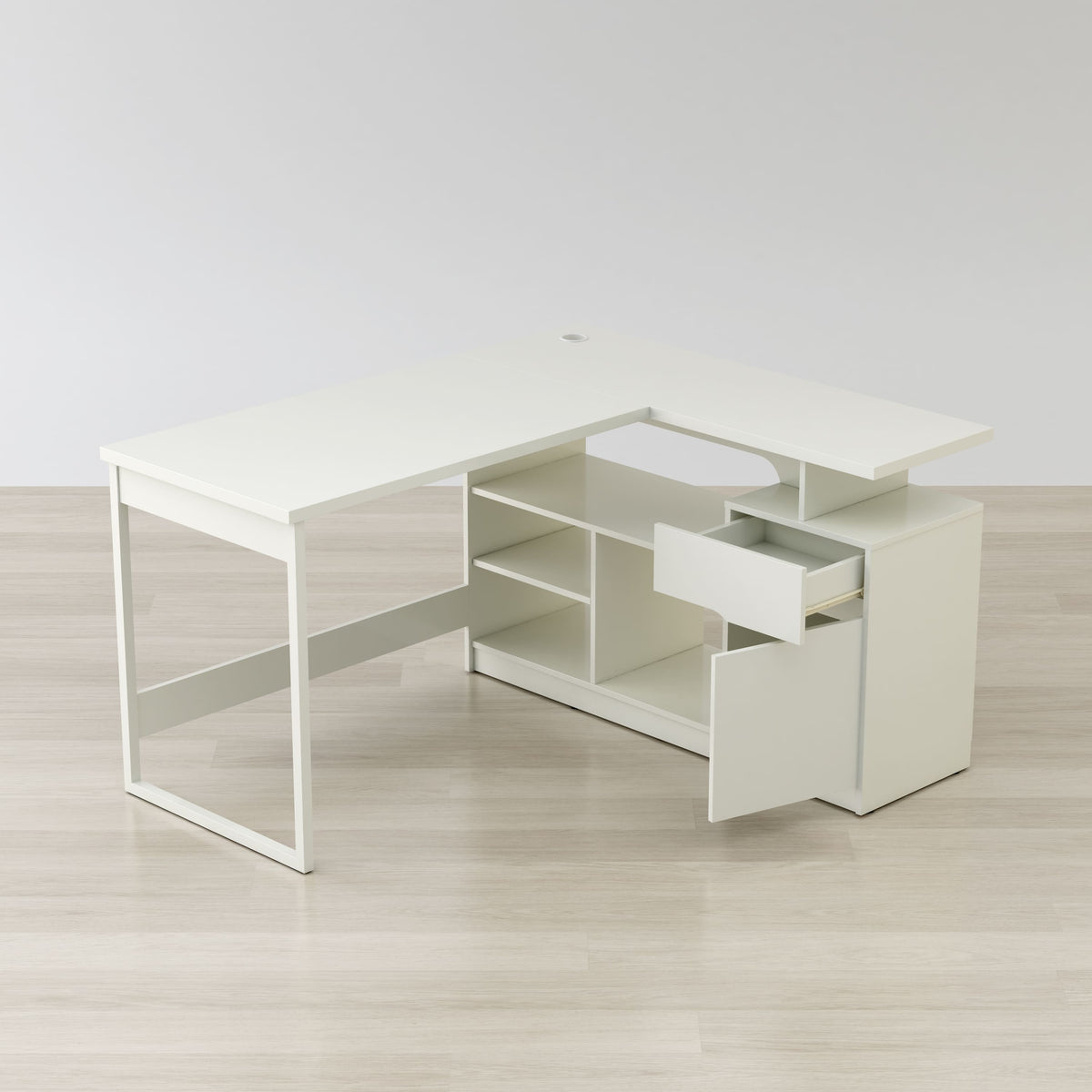 White L-shaped desk with a drawer on a light wooden floor.