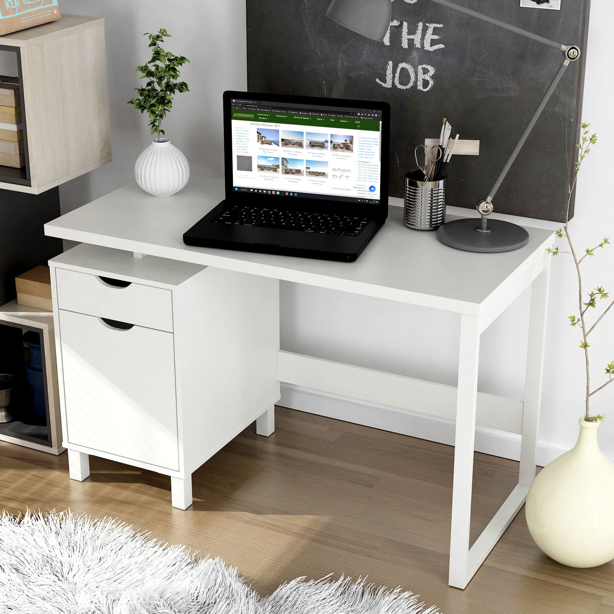 White desk with a laptop, office supplies, and a chalkboard wall in a home office setting.